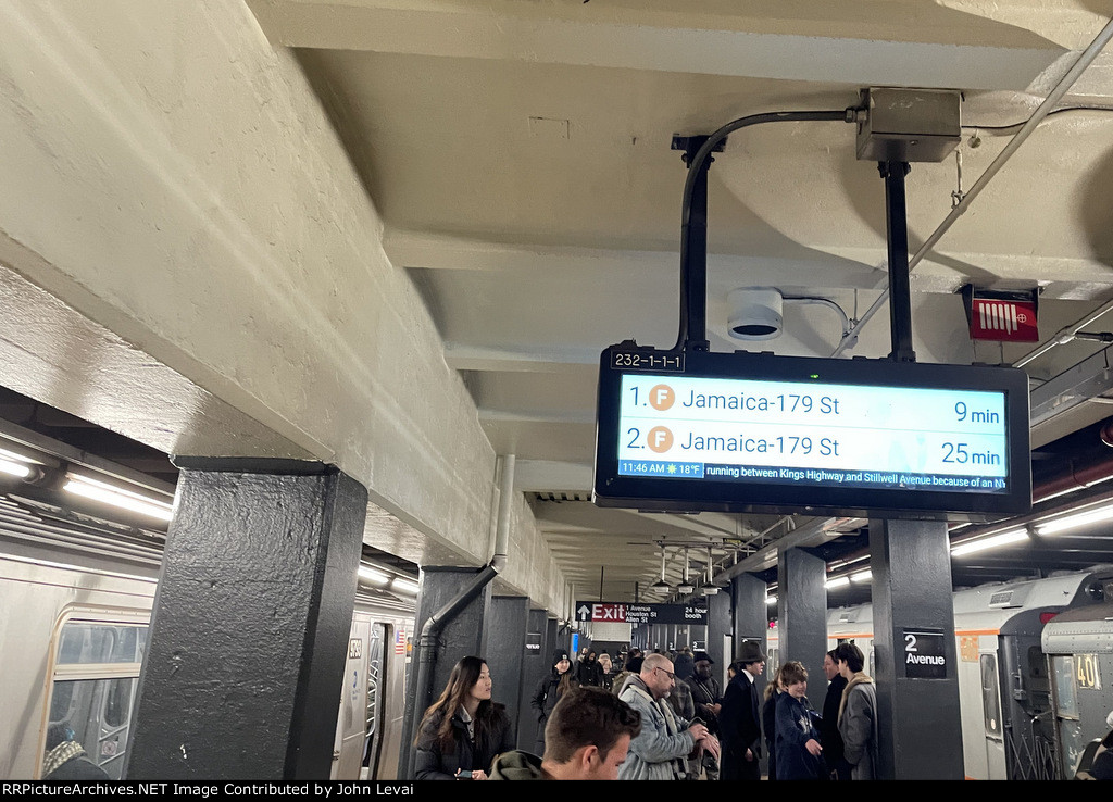 The regular F train on the left and the holiday train on the right, both at 2nd Ave Sta